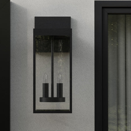 Modern wall sconce mounted on a white wall with black trim.
