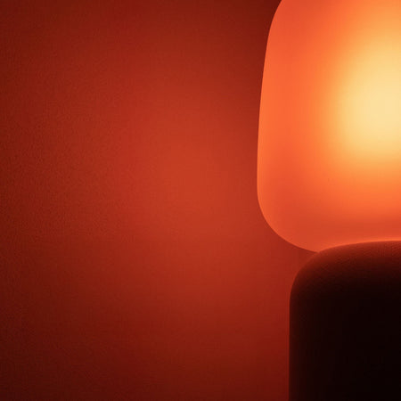 Close-up of a glowing light bulb against a red background