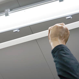 hand installing Feit Electric LED fluorescent linear tune bulbs in shop light
